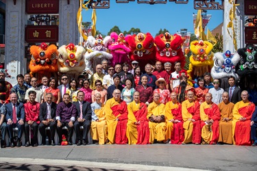 Group photo of the Councillors, monks, guests in traditional Chinese clothing and colourful lion dancers