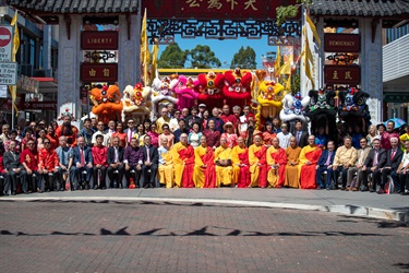 Group photo of Councillors, monks, guests wearing traditional Chinese clothing and colourful lion dance performers