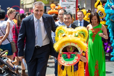 Mayor Frank Carbone waling with Councillor Kien Ly, Councillor Adrian Wong and Councillor Dai Le walking with young boy in golden lion dancing costume