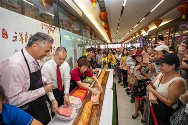 Mayor Frank Carbone, Councillor Adrian Wong, Andy Trieu and elderly baker placing Vietnamese brawn meat into bread rolls