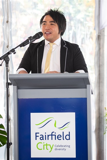 Man standing at a podium and speaking into a microphone