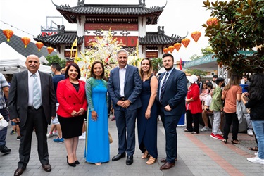 Mayor Frank Carbone, deputy mayor Dai le, Carmen lazar, George Barcha, Marie Saliba and Michael Mijatovic smiling and posing in front of Pai Lau Gate in Freedom Plaza