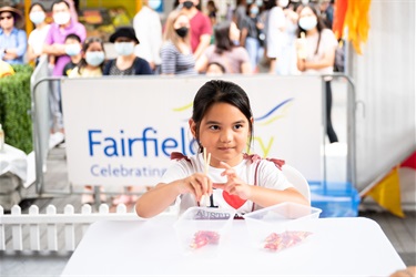 Young girl smiling while competing in the chopstick challenge