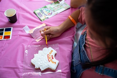 A cookie being painted by a young girl
