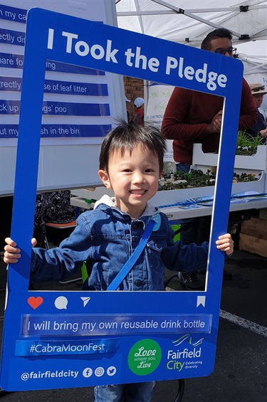 Young boy smiling and posing with Instagram photo booth prop