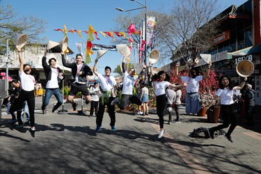 Young volunteers posing jumping mid air and holding conical hats