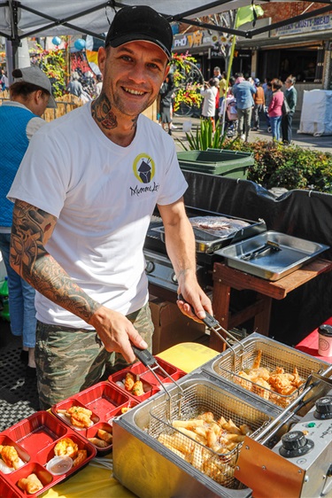 Man smiling and posing while cooking springrolls