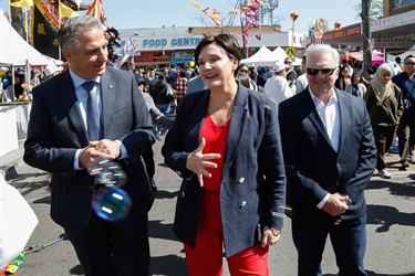 Mayor Frank Carbone smiling while watching the woman beside him speaking