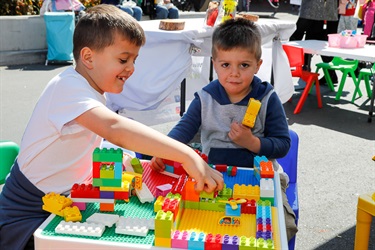 Two young boys playing with colourful building brick blocks