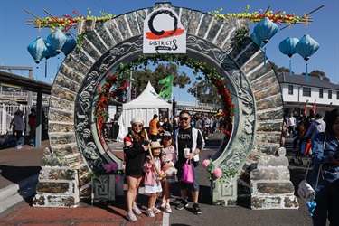 Family smiling and posing while standing under District 8 archway