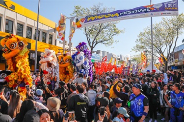 Crowd of guests watching colourful lion dancing puppets and red dragon dancing puppet