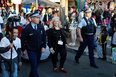 Crowd of guests walking down street with police officers