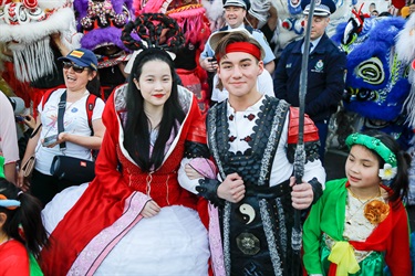 Young woman and man dressed as the Chinese Moon Goddess and Sun Archer, smiling and posing