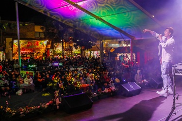 Kevin Kim singing into microphone to a crowd