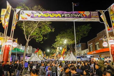 Crowd of guests walking through John Street under Moon Festival banners