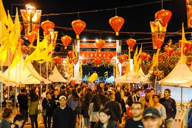Crowd of guests walking through Freedom Plaza under red lanterns and yellow flags