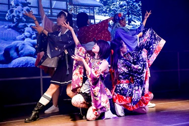 Women wearing contemporary adaptation of traditional Japanese clothing performing dance on the stage