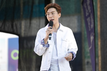 Korean pop idol Kevin Kim speaking into a microphone