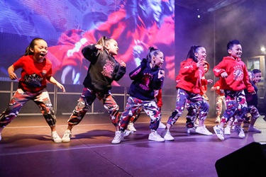 Kookies N Kream dance team performing hip hop routine on the stage