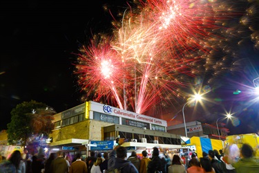 Crowd of guests watching red and yellow fireworks in the sky