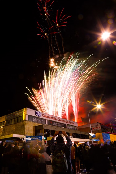 Crowd of guests watching colourful fireworks in the night sky