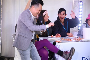 Group of people sitting at a table and eating prawns