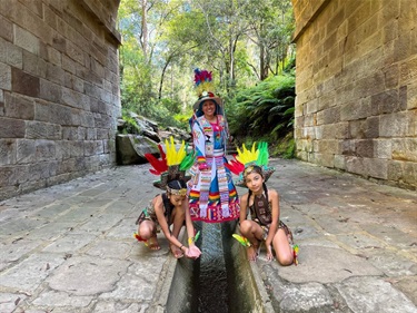 a woman with two girls dressed in traditional clothing