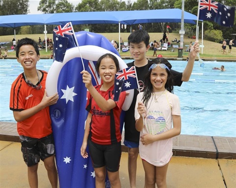 Australia Day celebrations with 4 kids holding flags by the pool
