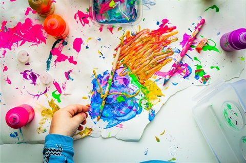 splattered paint, art equipment and child's hand