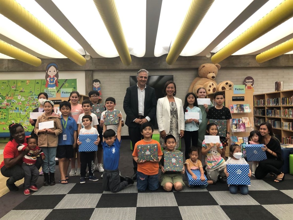 Mayor Frank Carbone, Deputy Mayor Dai Le and children posing for group photo in library