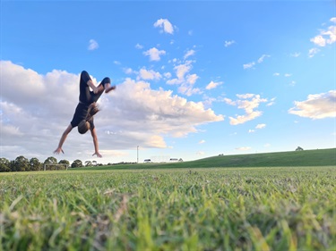 photo of a girl doing a backflip at the park