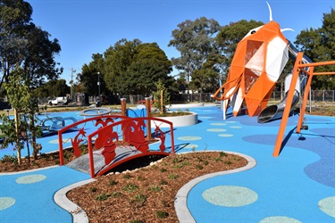 View of Koi shaped play equipment and small bridge at Bareena Park