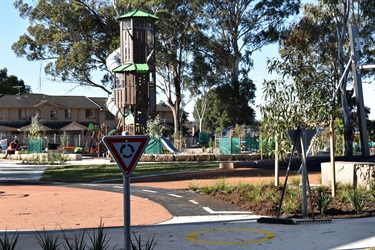 View of Fairfield Heights Park with tricycle path, climbing fortress and slide