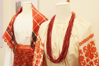Two red and white patterned traditional cultural costumes modelled on mannequins 