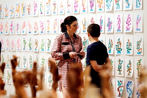 Woman and young boy looking at a wall of illustrations of colourful shapes