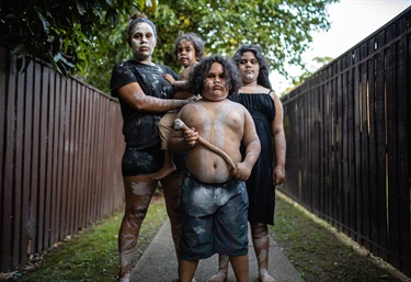 Portrait of a mother and her three children proudly wearing ochre body and face paint