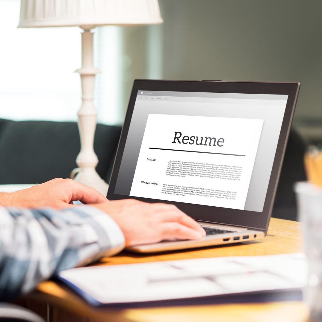 Close-up of someone working a resume on their laptop text on screen reads resume