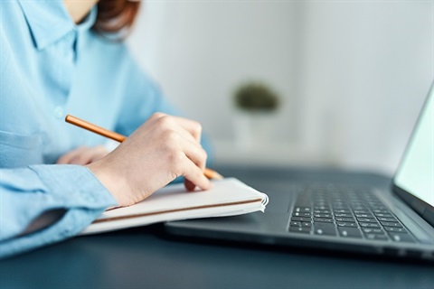 Lady with writing pad, pencil and laptop
