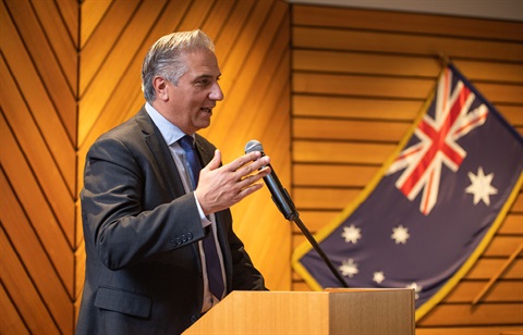 Mayor Frank Carbone giving a speech with the Australian flag visible in the background