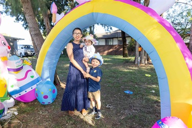 2025 Easter family photo in front of colourful arch.