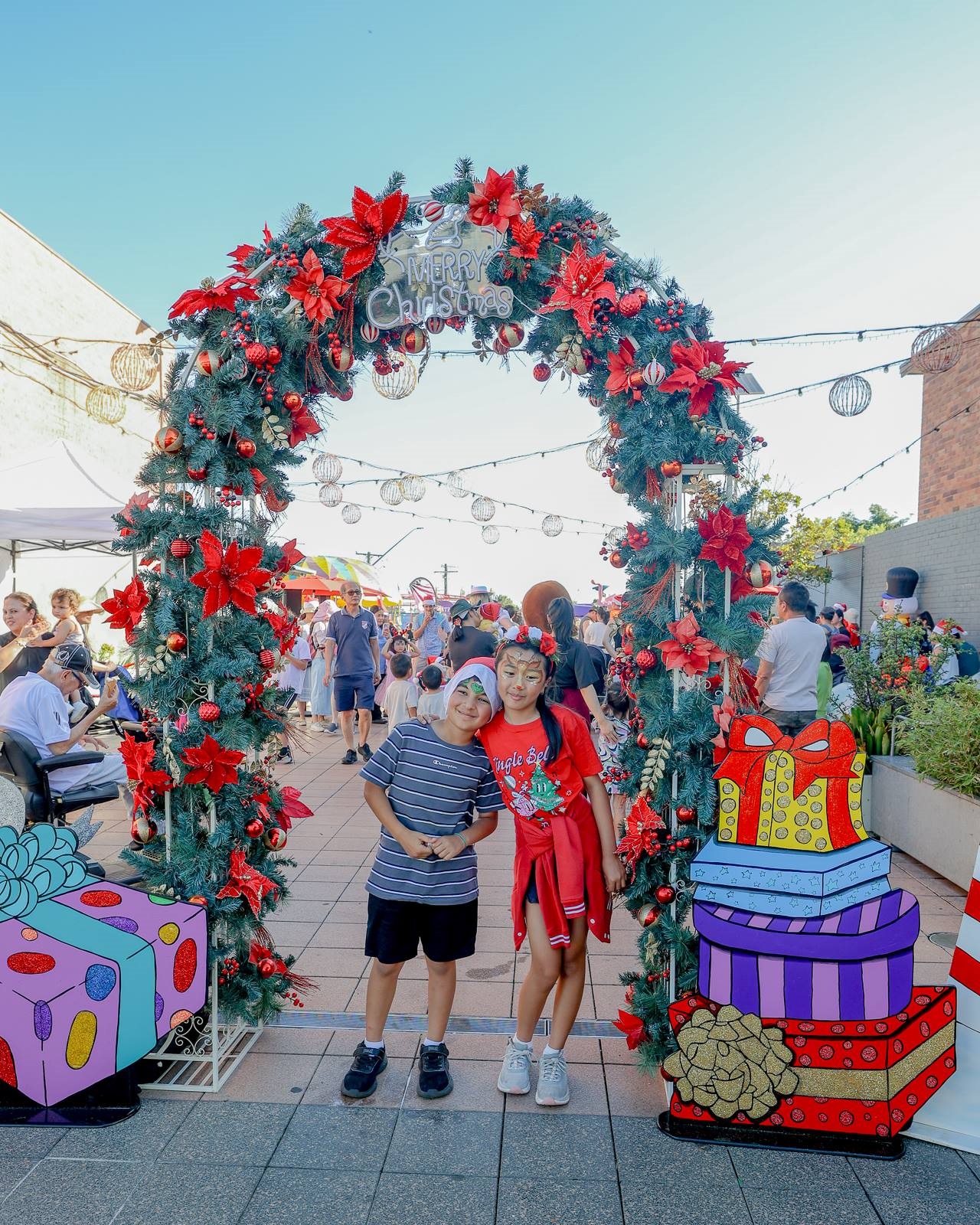 Kids standing front of Christmas arch in Canley Heights Town Square.