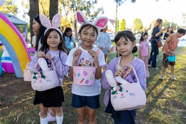 Little girls posing with Easter baskets at Easter Egg Hunt in Canley Vale.
