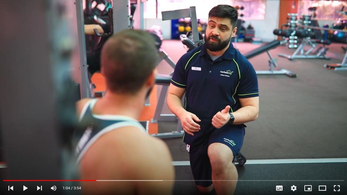 video screenshot of two men talking in the gym