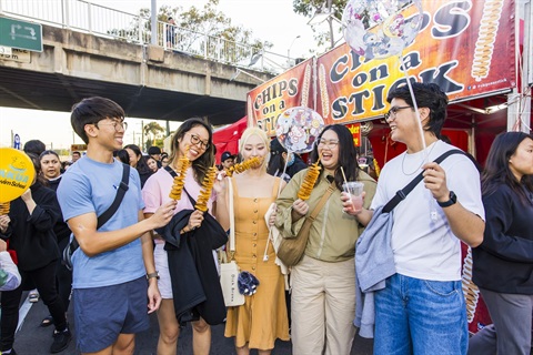 2024 Cabramatta Moon Festival group eating chips on a stick by Anna Kucera.