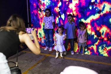Four kids with neon face painting against neon backdrop