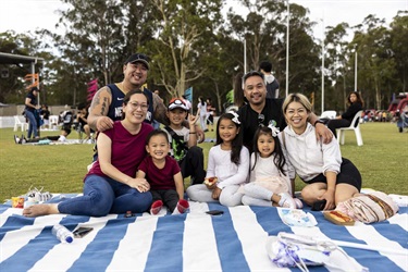 Family sitting on picnic blanket