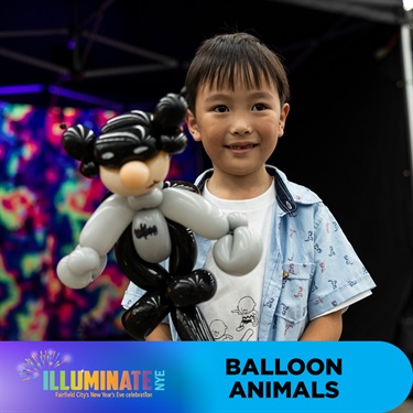 Young kid holding batman balloon animal