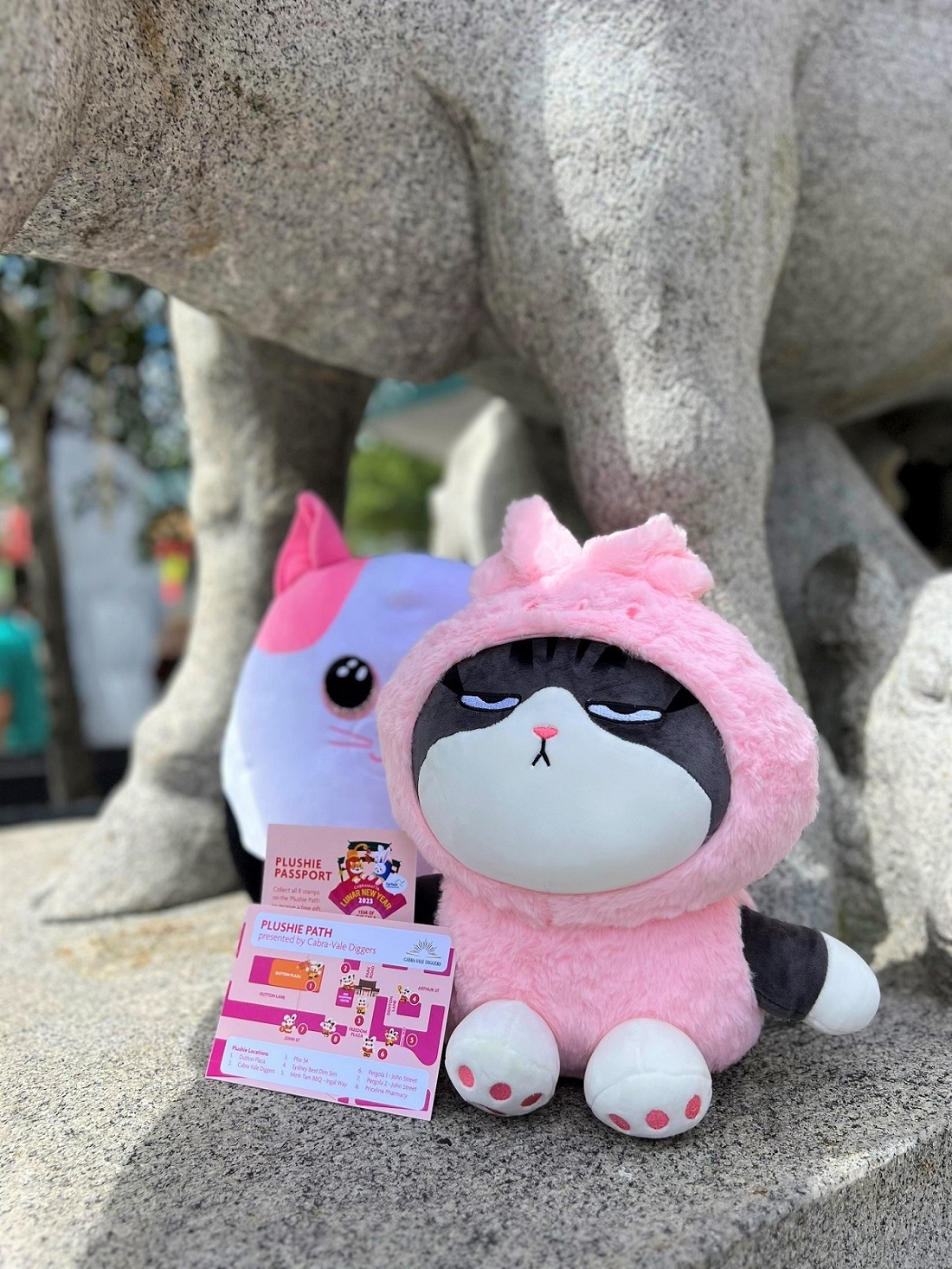 Cat and rabbit Plushie sitting by statue in Freedom Plaza Cabramatta