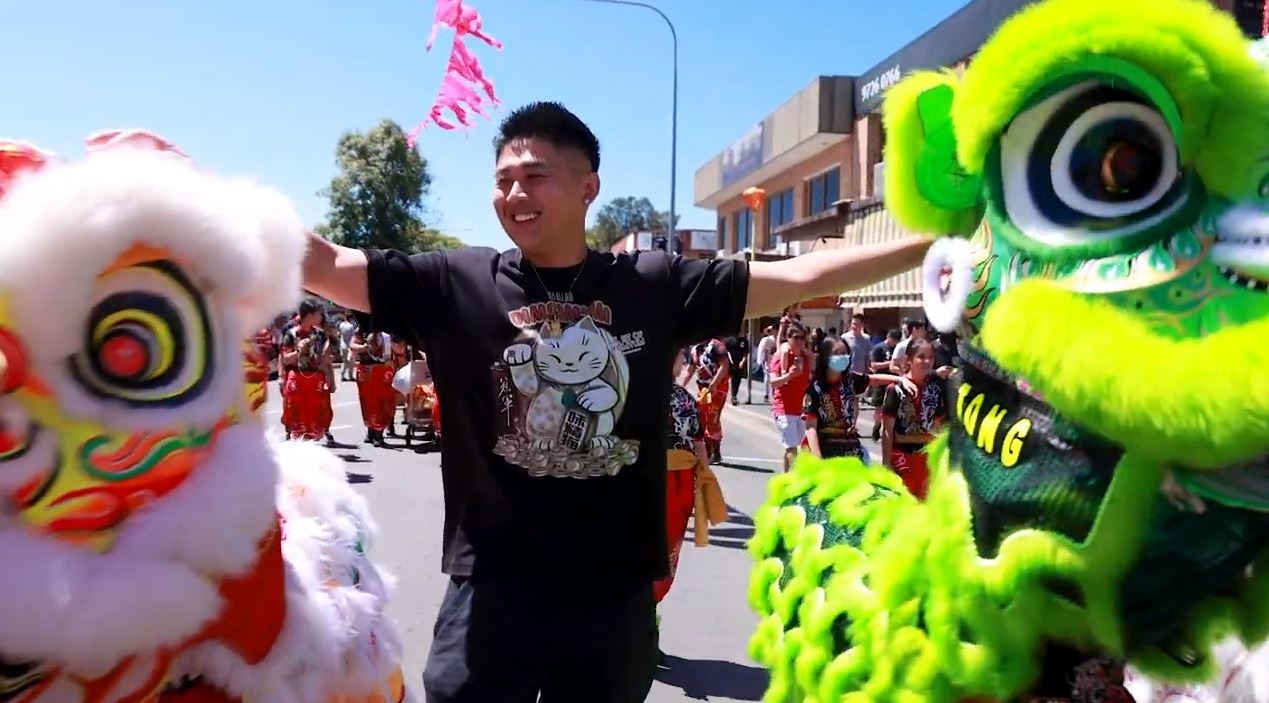 Man standing between two lion dancers