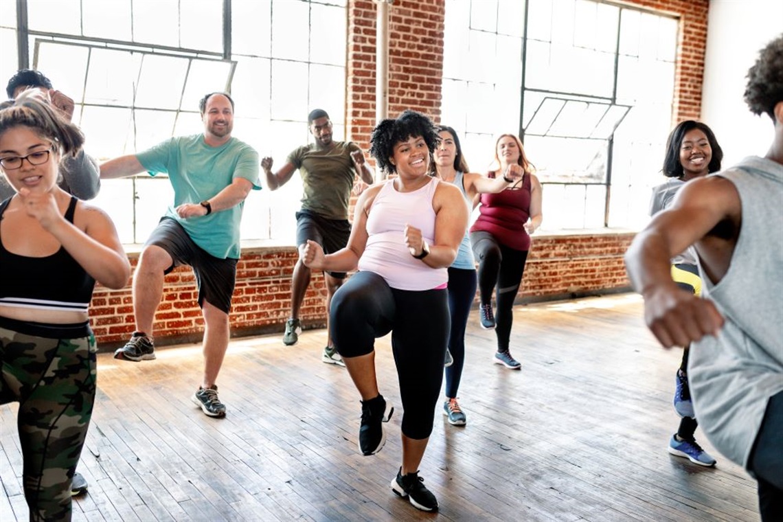 A group of people is doing some poses in a Zumba Class